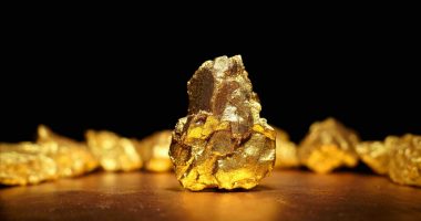 Visual representation of a large gold nugget sitting afore a black background.